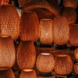 A collection of handmade woven lamps with warm glow indoors, showcasing traditional craftsmanship.